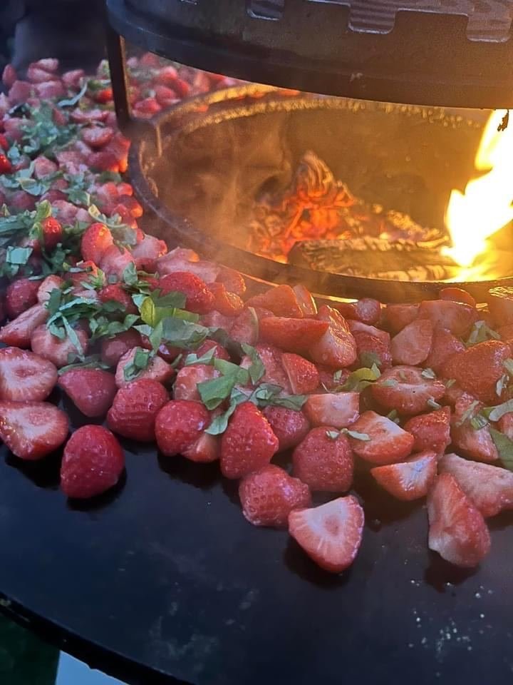 Aardbeien en fruit naast het vuur